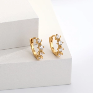 Macro shot of 925 sterling silver stamp on gold plated huggie earrings with zirconias