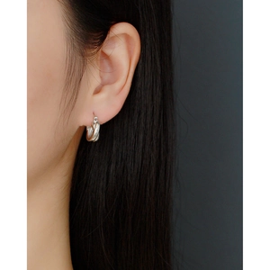 Close-up of minimalist S925 silver criss-cross hoop earrings on a female model