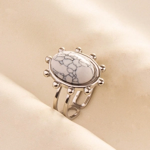 Detail of silver stainless steel ring with oval white marble stone and hollow band