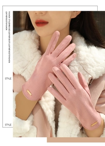 Detail of pink suede winter gloves with plush lining and decorative metal logo tag