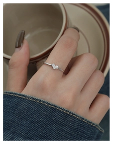 Close-up of minimalist S925 sterling silver heart ring with micro zircon on female finger