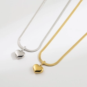 Close-up of gold and silver snake chain necklaces with 3D heart-shaped pendants
