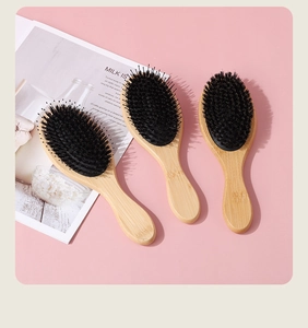 Bamboo hairbrushes with black bristles and massage pins on a pink minimalist background