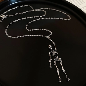 Detailed close-up of a silver skull pendant necklace with movable joints and metal chain