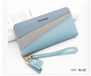 Blue and gray long zipper wallet with wrist strap and tassel on a magazine background