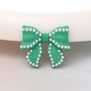 Detail of mint green bow charm with white pearl border for DIY jewelry making