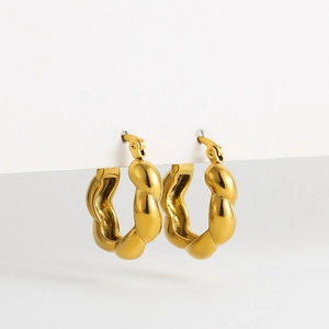 Detailed view of golden twisted hollow earrings with a high-polished mirror finish and clasp