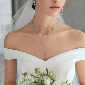 Detailed view of silver bridal jewelry set with tiered teardrop zircon necklace and earrings