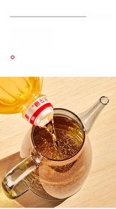 Macro shot of wide mouth glass oil dispenser featuring amber thick glass and easy pour spout