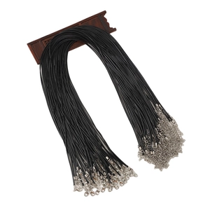 Macro shot of black wax cord necklaces bundle with silver lobster clasps on a wood stand