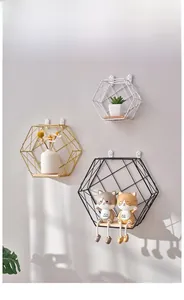 Close-up of three hexagonal geometric metal wall shelves with light wood bases
