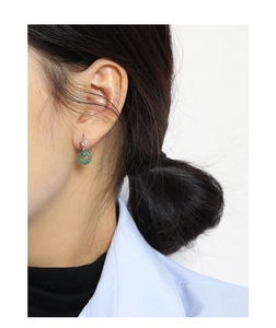 Close-up of elegant S925 sterling silver earrings with green jade donuts on model