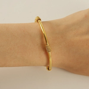 Détail du bracelet serpent doré orné d'anneaux filetés sur la surface lisse