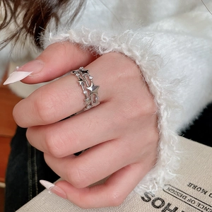 Detail of silver triple-layered star ring with zircon stones worn by a model