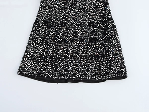 Detailed view of black and silver sequin hem on a sleeveless bodycon party dress