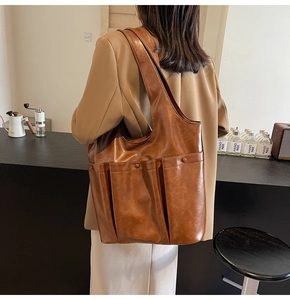 Detailed side view of vintage brown PU leather bucket bag featuring external patch pocket