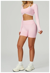 Detailed knit texture and seamless contrast design of the pink yoga top and sports shorts