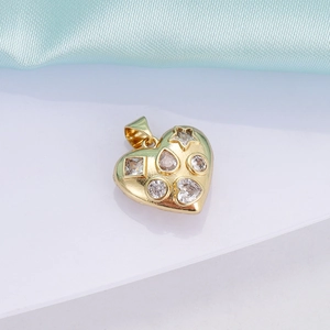 Detailed view of an 18K gold heart pendant set with various shaped zircon gemstones