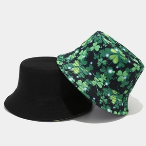 Foldable reversible bucket hat featuring black side and green shamrock print pattern