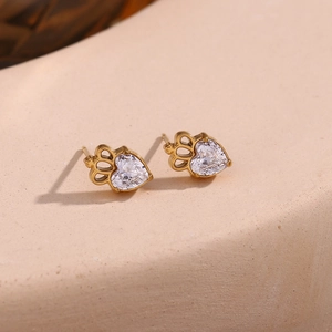 Detailed macro shot of 18K gold-plated crown earrings with heart-shaped zirconia