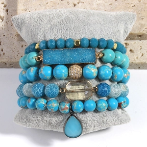Detail of 5-piece bohemian stackable bracelets with blue natural stones and gold beads