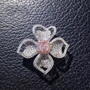 Detailed close-up of a luxury flower ring with pink gemstone and white diamonds