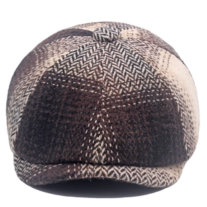 Detail of deep brown herringbone newsboy cap featuring thick tweed texture and classic patterns