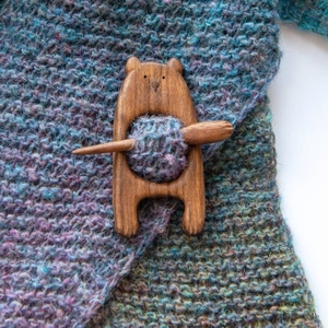 Handcrafted wooden bear brooch pin with fastener bar on knitted blue fabric sweater