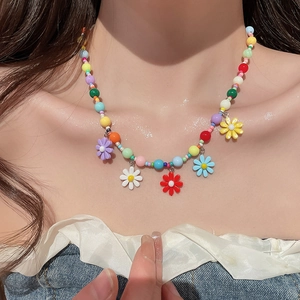 Colorful beaded daisy necklace close-up on model neck with resin flower pendants