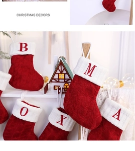 Close-up of classic red knit Christmas stockings with white cuffs and embroidered letters