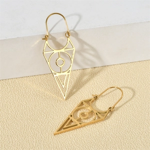 Gros plan de boucles d'oreilles géométriques dorées évidées sur un fond texturé