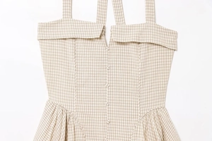 Detailed view of the plaid pattern and front button closure on the halter dress