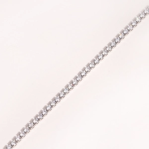 Detailed close-up of a silver tennis bracelet with brilliant cubic zirconia in a prong setting