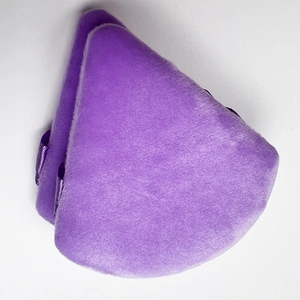 Close-up of a soft purple triangular velvet powder puff with silky ribbon detail