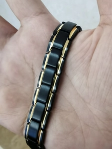 Detail showing the black and gold magnetic therapy links on the titanium steel bracelet