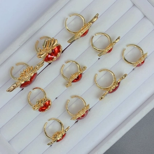 Detailed top view of red heart wing rings with cubic zirconia on white velvet tray