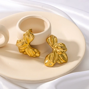 Luxury 18K gold-plated leaf drop earrings elegantly displayed on a ceramic tray