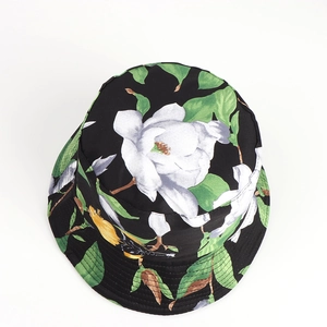 Close-up of floral bucket hat featuring white flowers and yellow birds on black fabric