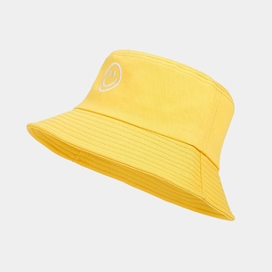 Gros plan d'un chapeau bob jaune en coton avec broderie smiley blanc et surpiqûres