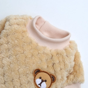 Dettaglio del maglione di peluche marrone per animali con ricamo di orso e colletto