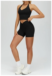 Detail of black halter neck sports bra and high-waist yoga shorts with ribbed texture