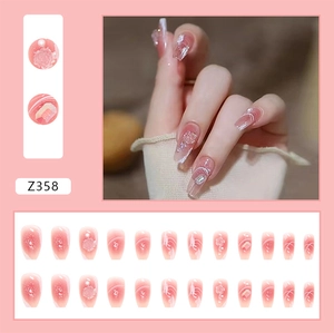 Detailed view of pink gradient press-on nails with 3D floral accents, pearls and rhinestones