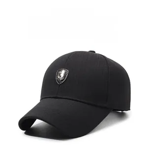 Detail of black baseball cap showing textured fabric and metallic shield logo badge