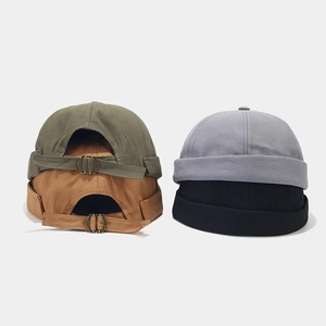 Détails de quatre bonnets docker en coton avec boucles métalliques réglables