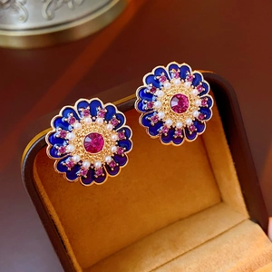 Macro detail of vintage blue enamel flower earrings with pink rhinestones and pearls