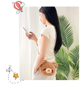 Close-up of a cute brown plush bear crossbody coin purse worn by a model in natural light