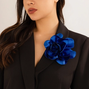 Detail of a royal blue satin flower brooch pinned on a black suit jacket lapel
