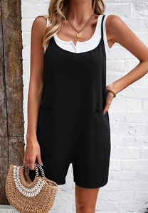 Detail of black casual jumpsuit with front pockets paired with a ribbed white tank top
