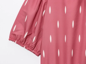 Vue détaillée des poignets plissés élastiques sur une robe rose avec imprimés blancs