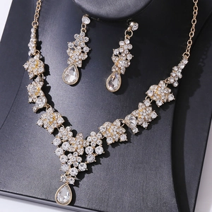 Detailed macro view of sparkling teardrop crystals on gold bridal jewelry set